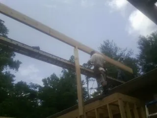Carpenter setting a ridge beam over a new addition frame — Ice Dam Removal by Roofing Brothers in Barryville