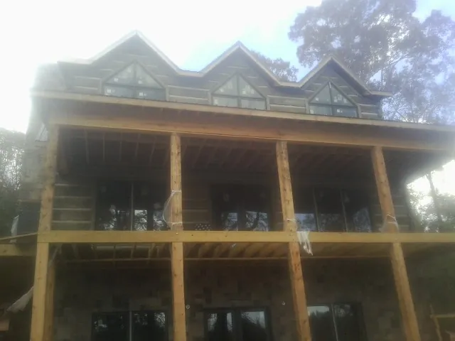 Dormers and porch framing on a large log home under construction — Roof Coating work by our crew in Barryville