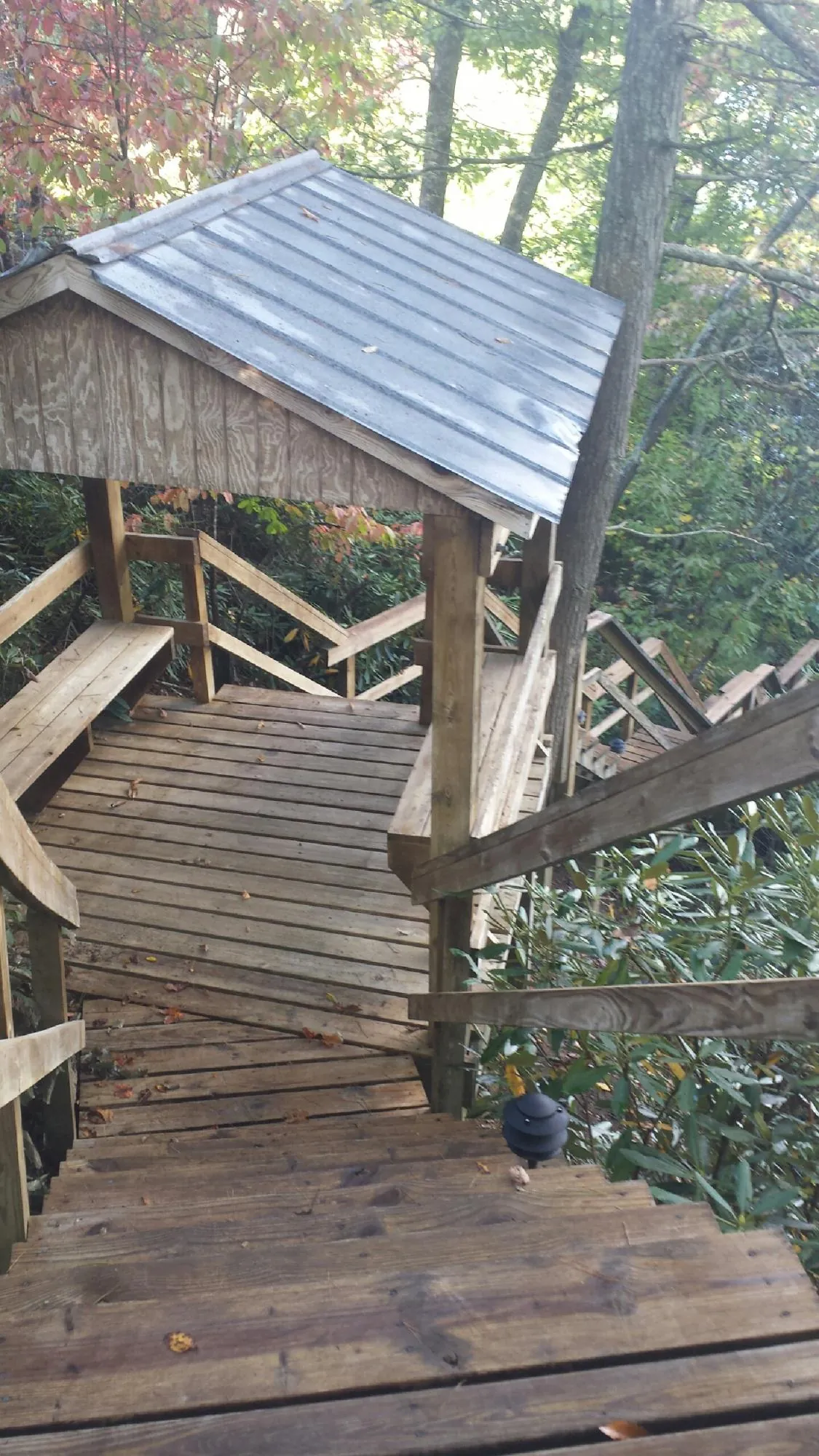 Metal roofed shelter over wooden steps on a wooded walkway — Skylight Repair & Installation work by our crew in Barryville